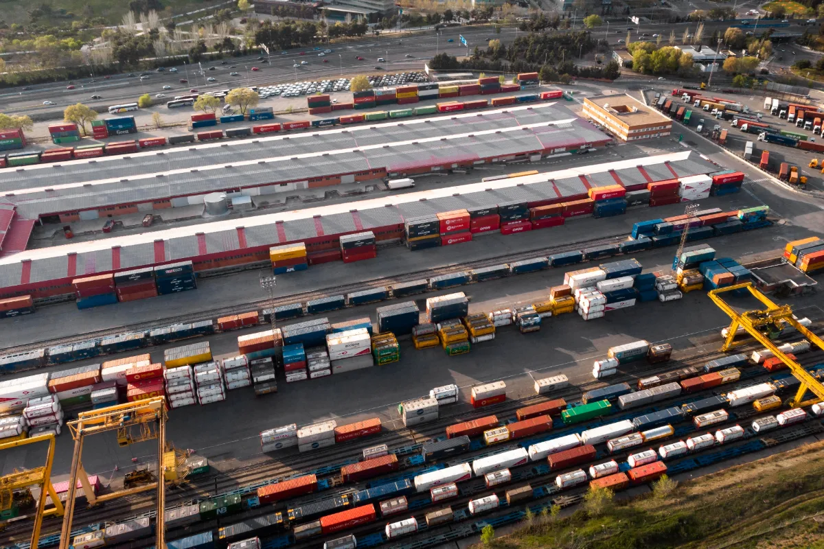 Kontenery transportowe ustawione przy torach kolejowych