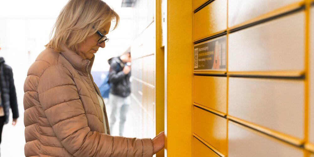 Kobieta nadająca przesyłkę kopertową w paczkomacie