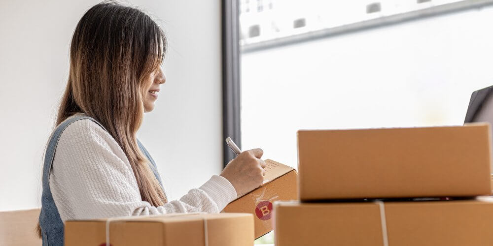 Kobieta nadająca dane na przesyłce kurierskiej