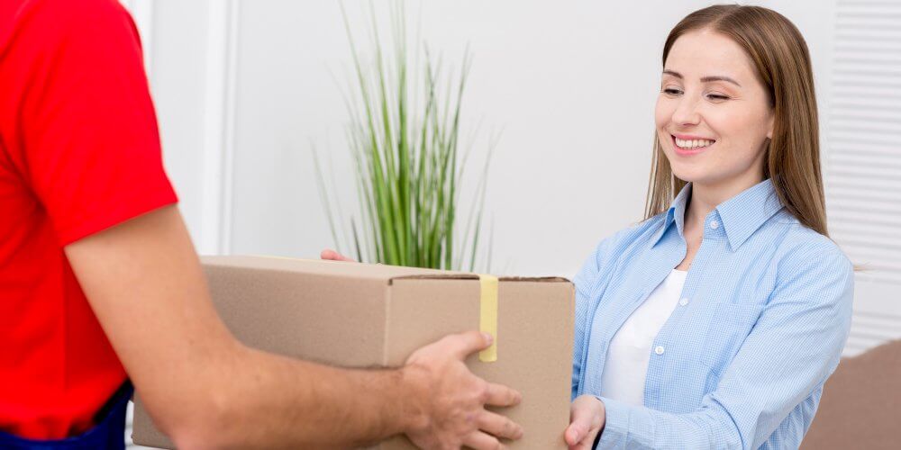 Kobieta odbierająca przesyłkę kurierską