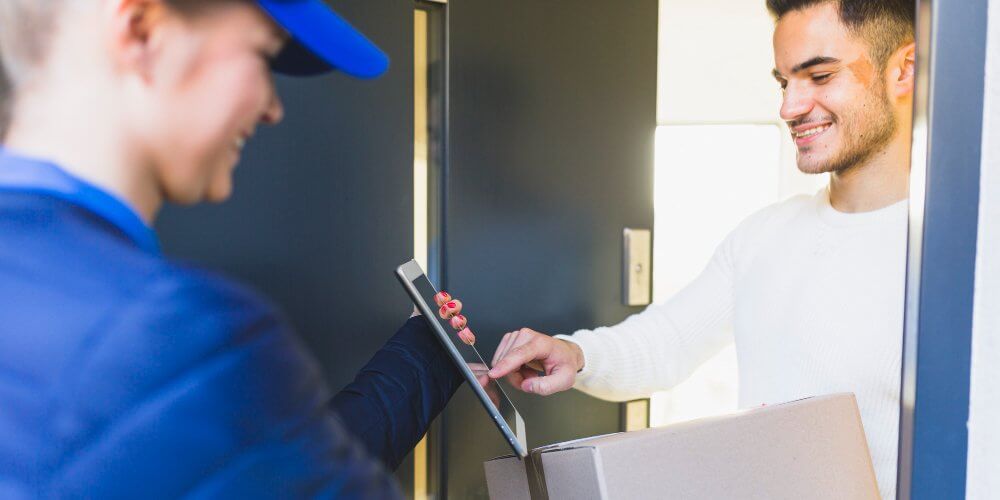 Mężczyzna odbierający przesyłkę od kuriera