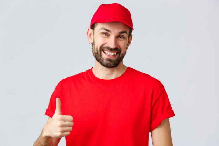 Uśmiechnięty Pan kurier w czerwonej koszulce